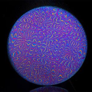 Puede incluir: Un disco metálico redondo con un patrón de remolino de azul, morado y naranja.
