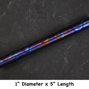 Puede incluir: Un tubo de metal iridiscente de 2,5 cm de diámetro y 12,7 cm de largo, azul, morado y dorado.