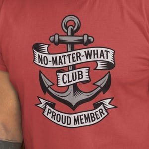 May include: Red t-shirt featuring an anchor graphic with the text "NO-MATTER-WHAT CLUB PROUD MEMBER". The design is in black and white. The t-shirt has short sleeves and a crew neck. The anchor graphic is centered on the chest.