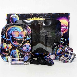 May include: A colorful smoking set featuring a tray with cartoon characters wearing sunglasses, a skull-shaped glass piece, a grinder, and a box with a cosmic design. The set includes a clear glass pipe and black accessories.