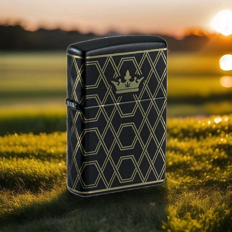Puede incluir: Encendedor negro con un patr&oacute;n geom&eacute;trico dorado y un emblema de corona. El encendedor tiene forma rectangular con tapa abisagrada y bisagra met&aacute;lica. El dise&ntilde;o presenta un patr&oacute;n repetitivo de l&iacute;neas y formas que se cruzan.