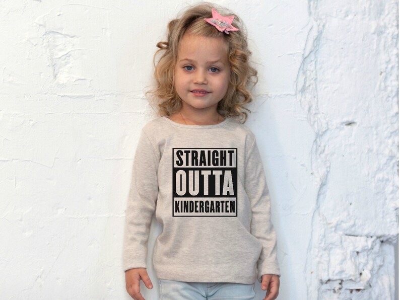 Puede incluir: Una camiseta de manga larga gris claro con un gr&aacute;fico negro que dice "STRAIGHT OUTTA KINDERGARTEN".