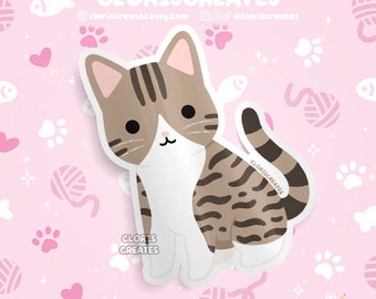 Puede incluir: Una linda ilustración de dibujos animados de un gato atigrado con rayas marrones y blancas. El gato está sentado con la cola enroscada alrededor de su cuerpo. El fondo es rosa con huellas de patas blancas y corazones.