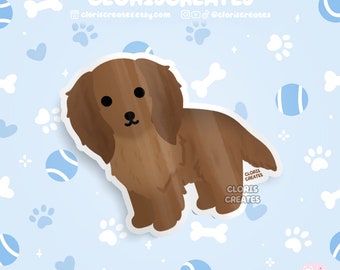 May include: A brown dachshund dog sticker with a white outline. The sticker is on a blue background with white paw prints and blue tennis balls.