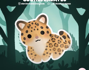 May include: A cute cartoon illustration of a brown and yellow spotted jaguar cub with big eyes and a pink nose. The cub is standing on all fours and looking to the left. The background is a green and blue forest scene.