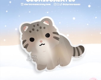 May include: A sticker featuring a cute cartoon cat with a light brown and gray color scheme. The sticker has the text "CLORISCREATES" and the Etsy shop URL. The background is a gradient of blue and white with small star shapes.