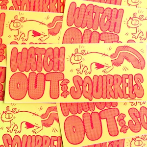 May include: A collection of yellow stickers with red text and illustrations. Each sticker features a cartoon squirrel and the words "Watch Out for Squirrels" in a bold, bubble font. The stickers have a retro, comic book style.