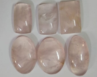 May include: Six polished rose quartz stones in various shapes, including oval and rectangular. The stones are translucent and have a light pink colour.