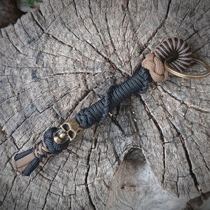 Paracord keychain, color black and coyote brown. Bronze metal skull.