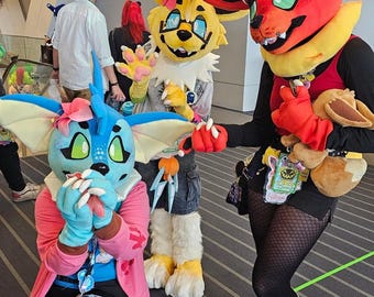 May include: Three full-body animal costumes featuring vibrant colors. One is blue with large ears and a pink flower, one is yellow with glasses, and one is red with a yellow collar. They wear accessories like badges and carry a small plush toy.