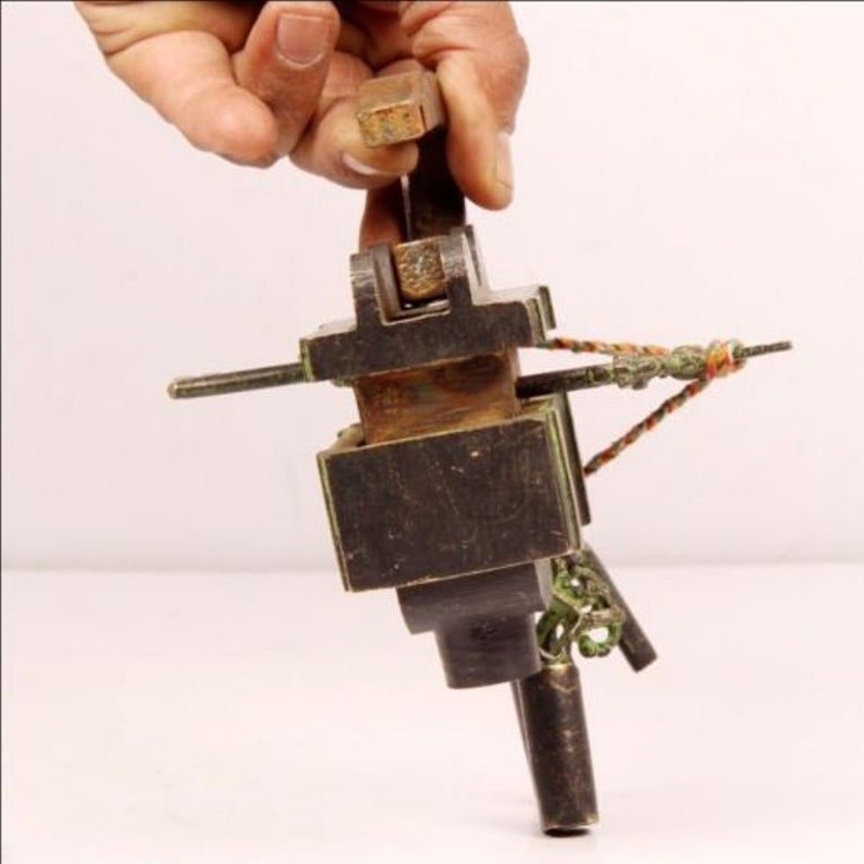 May include: A vintage, hand-crafted, wooden crossbow with a dark brown finish and green accents. The crossbow has a string and a small, wooden arrow.
