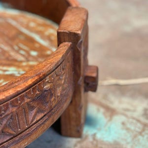 May include: Close-up of a handcrafted wooden tray with intricate carved details. The tray features a rich brown color with a natural wood grain. The edges are adorned with geometric patterns, showcasing the artisan's skill.