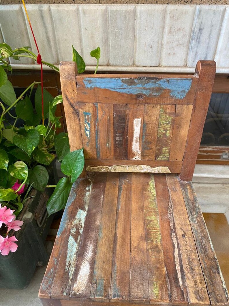 Puede incluir: Una silla de madera con un acabado desgastado. La silla est&aacute; hecha de madera recuperada y tiene un aspecto &uacute;nico y r&uacute;stico. La silla est&aacute; pintada en tonos de azul, verde y marr&oacute;n.