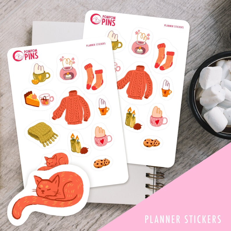 Op de afbeelding: Een set planner stickers met een knus winterthema. De stickers bevatten illustraties van een trui, een mok warme chocolademelk, een kat, kaarsen, sokken en een taart. De stickers zijn gedrukt op wit papier en hebben een matte afwerking. De tekst "PLANNER STICKERS" is gedrukt op de onderkant van het vel.