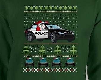 May include: Dark green sweatshirt with a festive design. The graphic features Santa Claus driving a black and white police car. The design includes Christmas trees and police cars, creating a holiday theme.