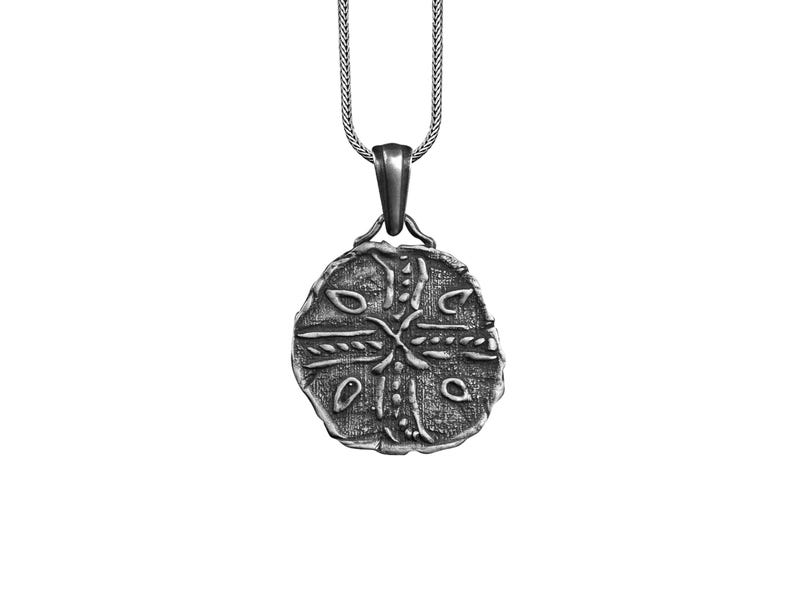 May include: Silver pendant necklace with a round, detailed, silver charm featuring a cross design.