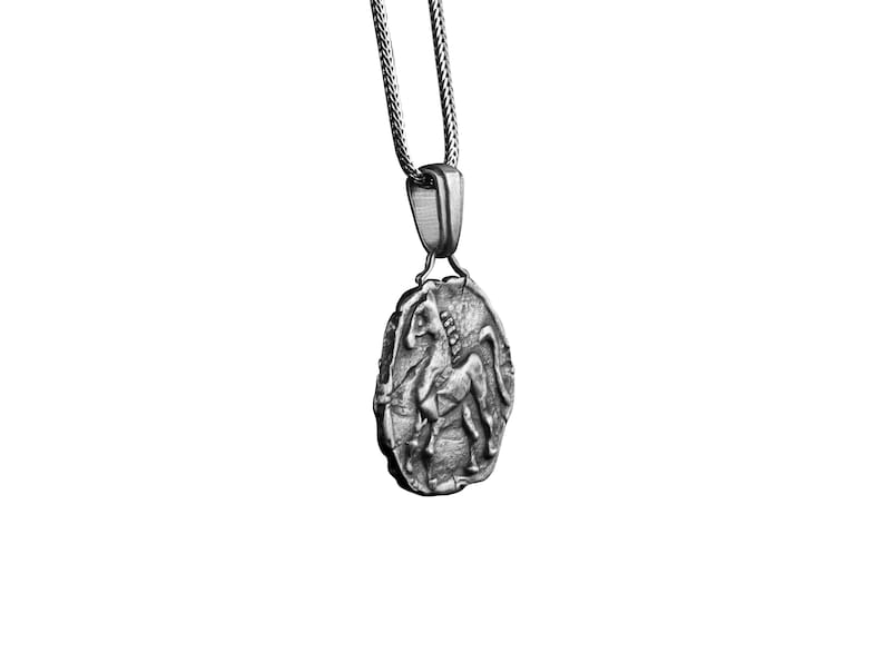 May include: A silver chain necklace with a pendant featuring a detailed, three-dimensional depiction of a mythical creature, possibly a centaur or a griffin.
