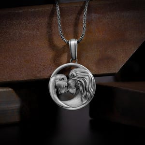 May include: A silver necklace with a pendant featuring two lion heads facing each other in a heart shape.