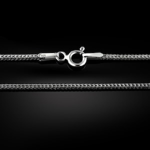 May include: A silver chain necklace with a lobster clasp. The chain is made of a braided design and is marked with "925" for sterling silver.