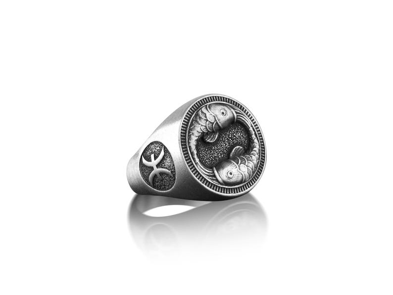 Peut inclure: Bague en argent avec un motif d&eacute;taill&eacute; de deux poissons entrelac&eacute;s, symbolisant le signe du zodiaque des Poissons. La bague pr&eacute;sente &eacute;galement le symbole des Poissons sur le c&ocirc;t&eacute;.