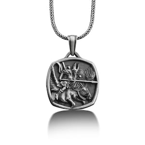 May include: Silver pendant necklace featuring a detailed depiction of a winged warrior riding a horse, holding a spear. The pendant is square shaped with rounded corners.