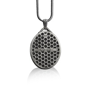 May include: Silver chain necklace with a round pendant featuring a honeycomb pattern and the text "Text me".