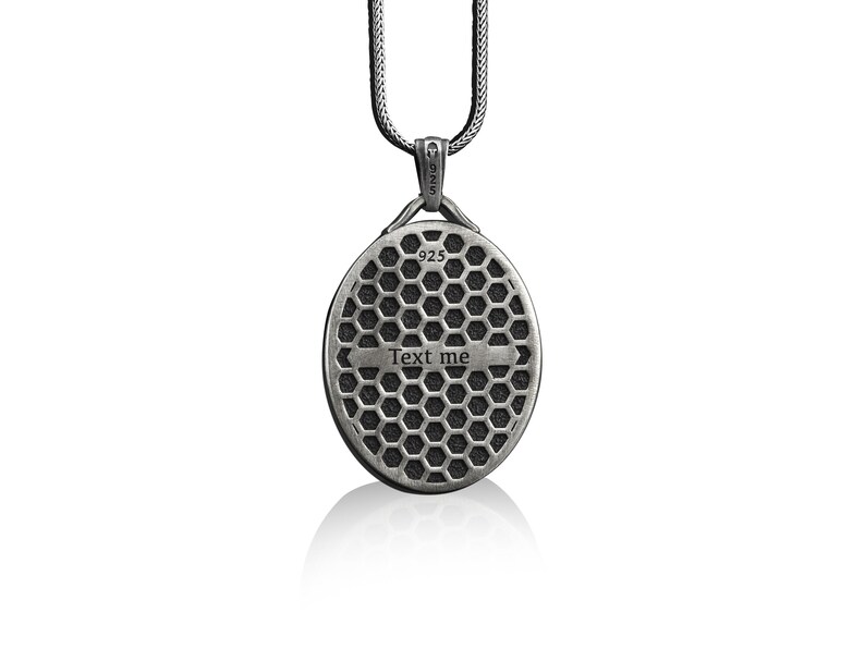 May include: Silver chain necklace with a round pendant featuring a honeycomb pattern and the text "Text me".