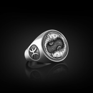 Peut inclure: Une bague en argent avec un motif d&eacute;taill&eacute; de deux poissons entrelac&eacute;s, symbolisant le signe du zodiaque des Poissons. La bague pr&eacute;sente &eacute;galement le symbole des Poissons sur le c&ocirc;t&eacute;.