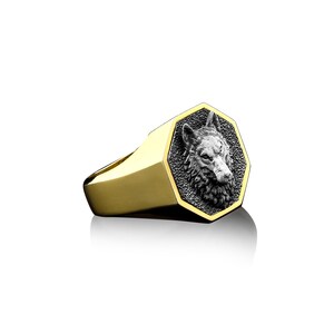 May include: A gold ring with a silver wolf head design. The wolf head is in a hexagonal shape and is detailed with a textured finish.