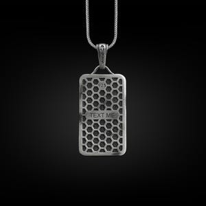 May include: Silver pendant necklace with a rectangular tag featuring a honeycomb pattern and the text "TEXT ME".