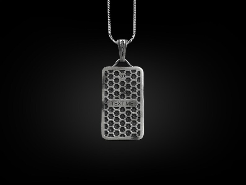 May include: Silver pendant necklace with a rectangular tag featuring a honeycomb pattern and the text "TEXT ME".