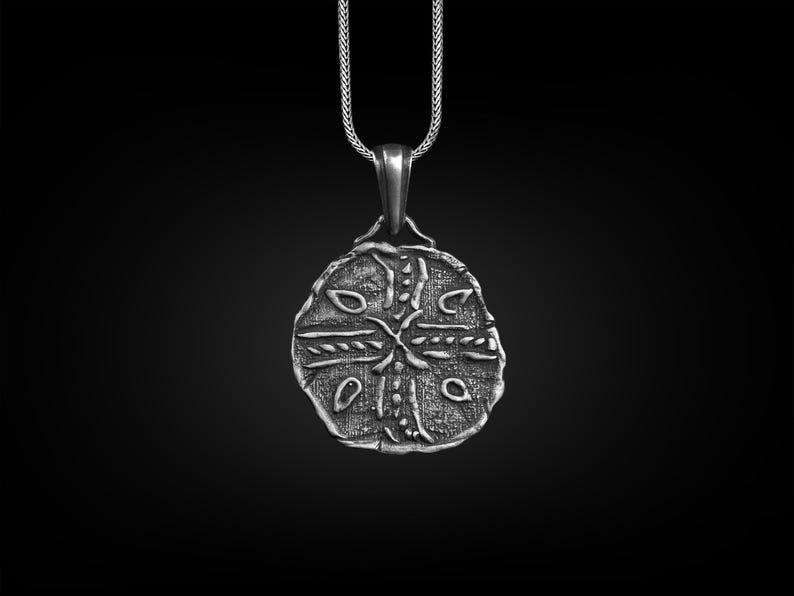 May include: Silver pendant necklace with a round, detailed design featuring a cross and intricate patterns. The pendant is on a silver chain.