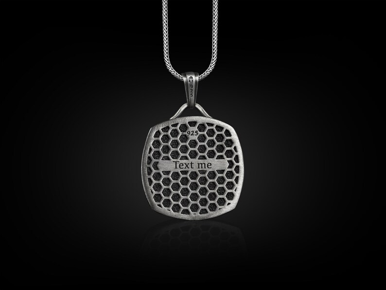 May include: Silver pendant necklace with a square-shaped charm featuring a honeycomb pattern and the text "Text me".