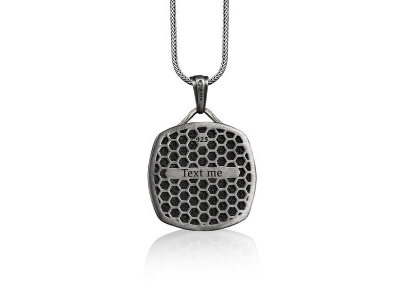 May include: Silver pendant necklace with a square-shaped pendant featuring a honeycomb pattern and the text "Text me".