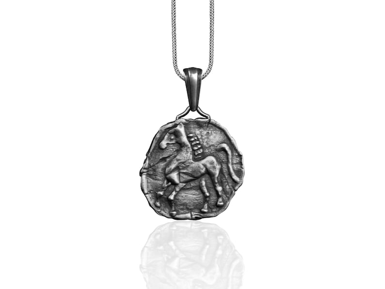 May include: Silver pendant necklace featuring a detailed relief of a horse. The pendant is oval shaped and hangs from a silver chain.