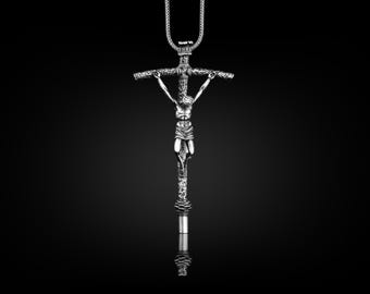 May include: A silver pendant necklace featuring a detailed crucifix with a figure of Jesus Christ.