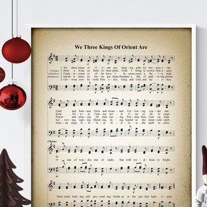 May include: Vintage sheet music print titled "We Three Kings Of Orient Are". The music notes are printed on a cream-coloured background with a faded, aged look.