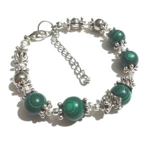 May include: A silver bracelet with green malachite beads and silver charms. The bracelet has a lobster clasp closure.