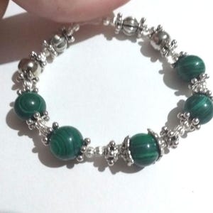 May include: A green malachite stone bracelet with silver beads and a silver clasp.