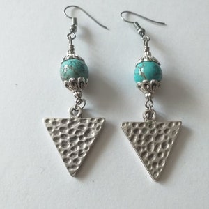 May include: A pair of silver earrings with turquoise beads and triangle pendants. The triangles have a hammered texture.