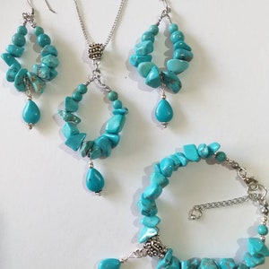 May include: Turquoise gemstone jewelry set with a necklace, earrings, and bracelet. The necklace and earrings feature a teardrop pendant and the bracelet has a silver clasp.