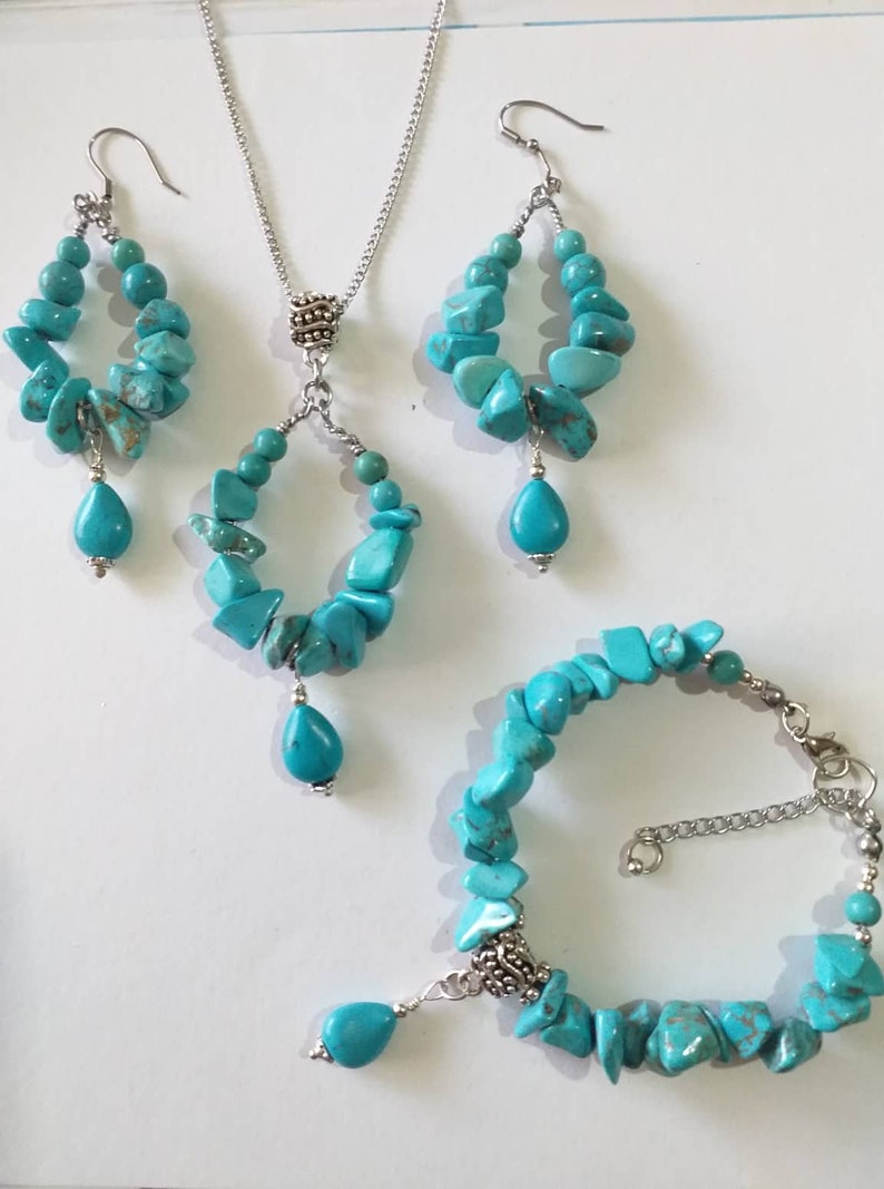 May include: Turquoise gemstone jewelry set with a necklace, earrings, and bracelet. The necklace and earrings feature a teardrop pendant and the bracelet has a silver clasp.