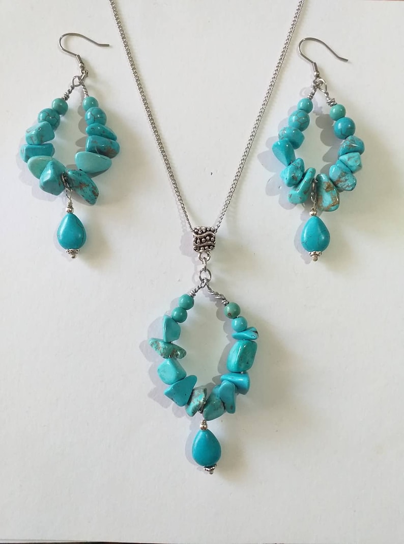 May include: A turquoise gemstone necklace and earrings set with a silver chain and a teardrop-shaped pendant.