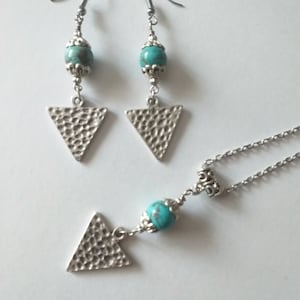 May include: A silver necklace and earrings set with turquoise beads and hammered triangle pendants.