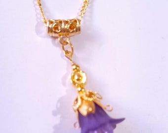May include: A gold chain necklace with a purple flower pendant. The flower is detailed with gold accents and has a delicate design.