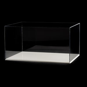 May include: A clear acrylic display case with a white base. The case is empty and has a rectangular shape.