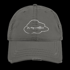 Puede incluir: Gorra de béisbol gris desgastada con bordado blanco de una nube con el texto "in my coffee".