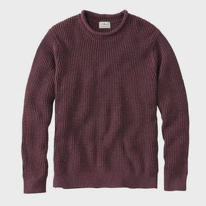 May include: A burgundy-colored crew neck sweater with a textured waffle knit design. The long-sleeved sweater has a ribbed hem and cuffs, and a small label is visible at the back of the neck.