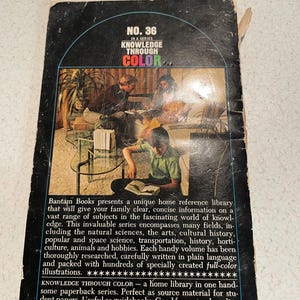 K&ouml;nnte beinhalten: Vintage Taschenbuchcover der Reihe "Knowledge Through Color" mit Retro-Design. Das Cover ist schwarz mit dem Titel und der Seriennummer in einer farbenfrohen Grafik. Das Buch ist eine Heimbibliothek.