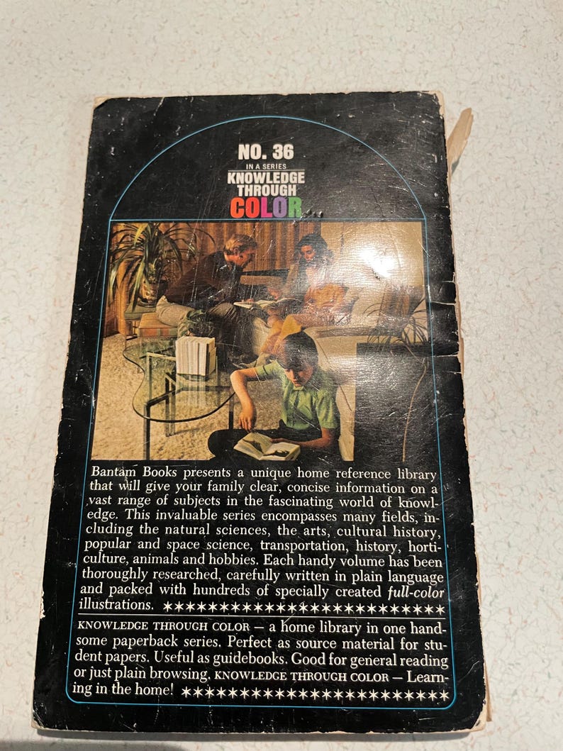 K&ouml;nnte beinhalten: Vintage Taschenbuchcover der Reihe "Knowledge Through Color" mit Retro-Design. Das Cover ist schwarz mit dem Titel und der Seriennummer in einer farbenfrohen Grafik. Das Buch ist eine Heimbibliothek.